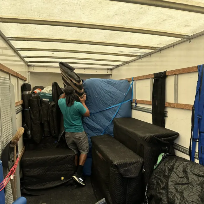 Trident Removals team loading padded and wrapped furniture into the removal van