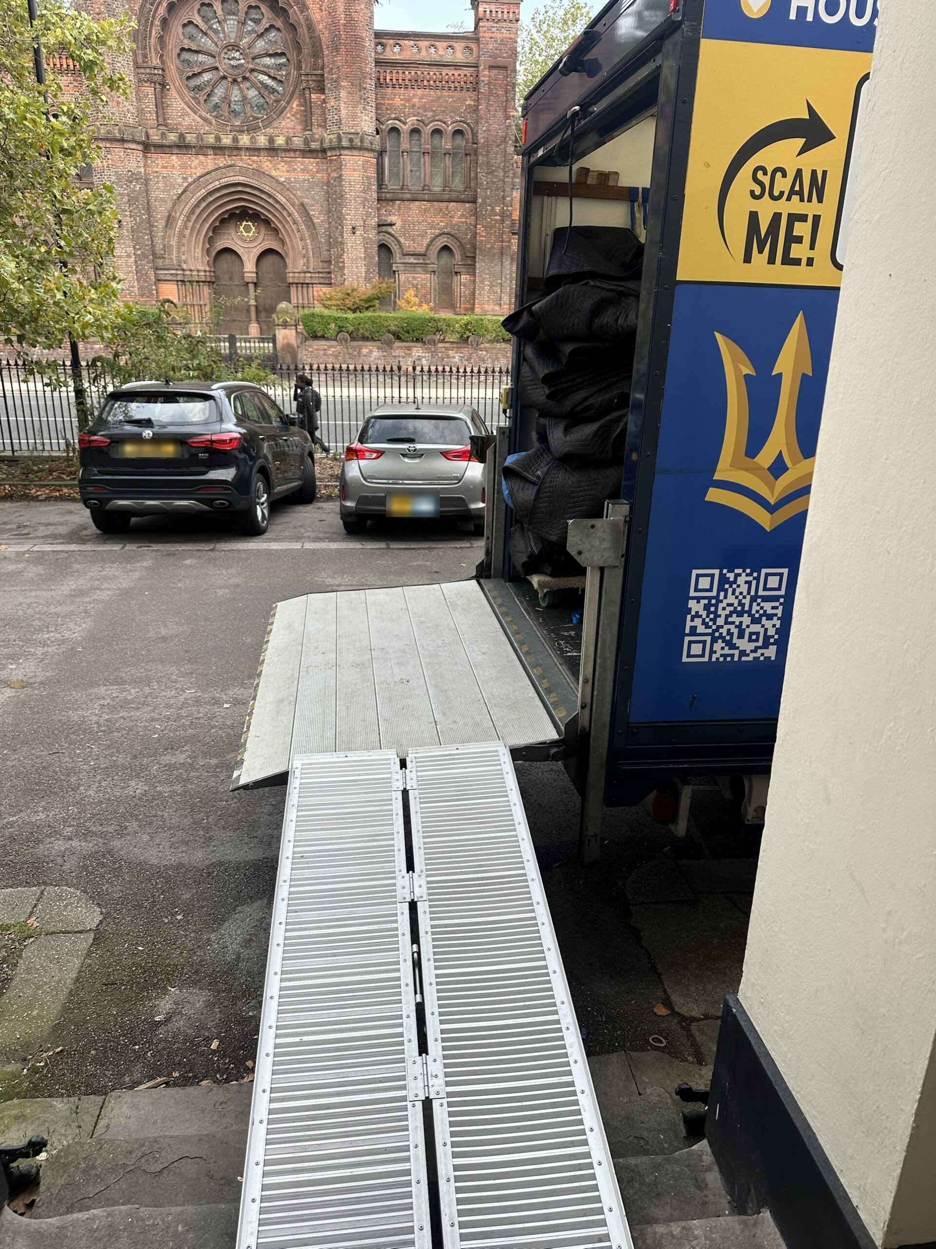 Folding ramp over the front steps onto the removal van tail lift during a Toxteth flat move
